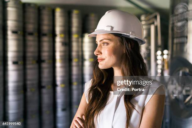 thoughtful worker wearing hardhat in brewery - thinktank stock pictures, royalty-free photos & images