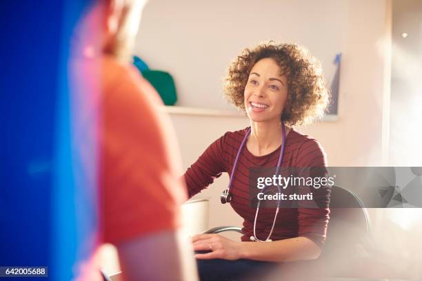 happy female doctor with patient - back lit doctor stock pictures, royalty-free photos & images