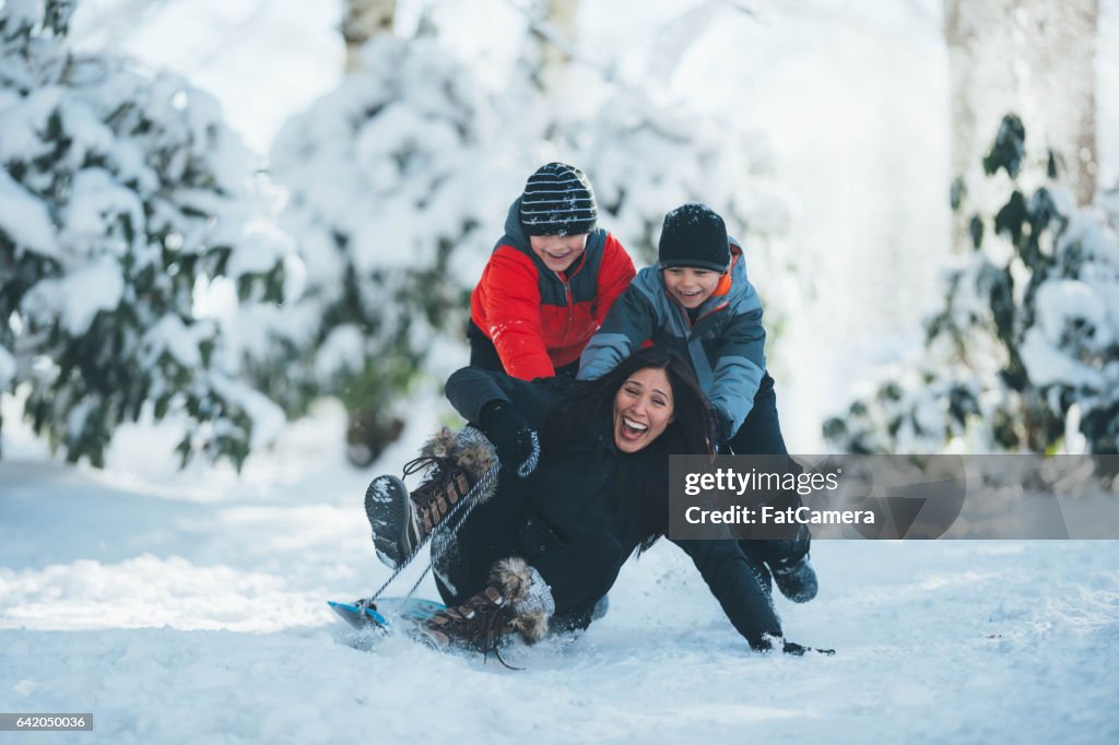 Moeder en zoons spelen in de sneeuw