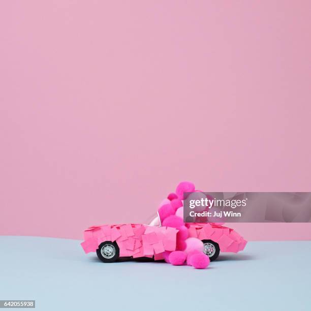 Toy car covered in paper and puffballs