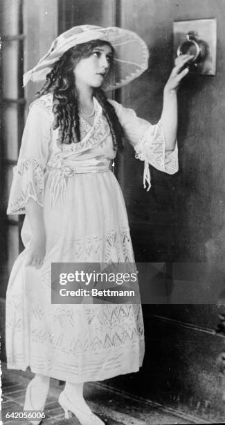 Publicity still recreating the homecoming scene in the silent film Rebecca of Sunnybrook Farm. The gown Mary Pickford wears in the scene was designed...