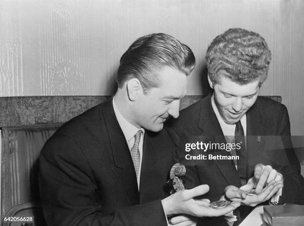 Musical Talents. Moscow, USSR: Soviet violinist Valery Klimov and US pianist Van Cliburn look at their gold medals after they triumphed in their...