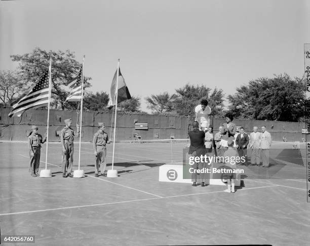 Alfredo Godoy, chief of Chile delegation to Pan American Games, presents gold medal to Althea Gibson , of N.Y., after she won the women's singles...