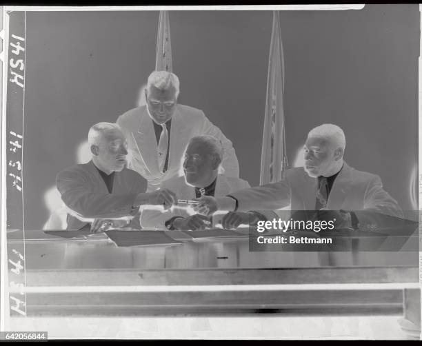 Sandy Saddler, , the world's featherweight champion, is shown with Commissioner Julius Helfand , and Teddy "Redtop" Davis, as Saddler and Davis...