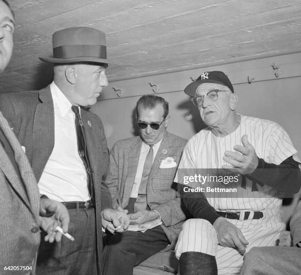 Manager Casey Stengel of the New York Yankees is shown in a dugout conference with baseball commissioner Ford Frick shortly before the first game of...