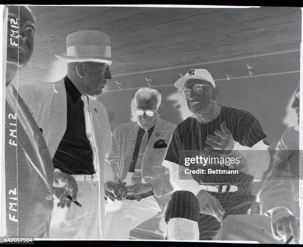 Manager Casey Stengel of the New York Yankees is shown in a dugout conference with baseball commissioner Ford Frick shortly before the first game of...