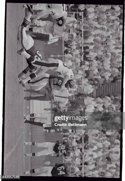 Chicago's Gale Sayers, evades Steeler defender Mike Clark with the help of a block by teammate Dug Buffone to pass the last obstacle on his way to...