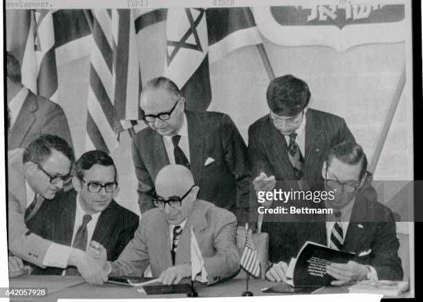 Treasury Secretary William Simon and Finance Minister Rabinowitz flanked by aides sign the agreement here 3/3 setting up a multimillion dollar...