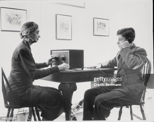 Photo shows Dr. Stella S. Center, director of reading clinic at New York University, making a hearing test with audiometer.