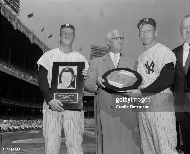 In pre-ball game ceremonies at Yankee Stadium, Tony Kubek, left, holds his "Rookie of the Year" award, and Mickey Mantle, right, is presented with...