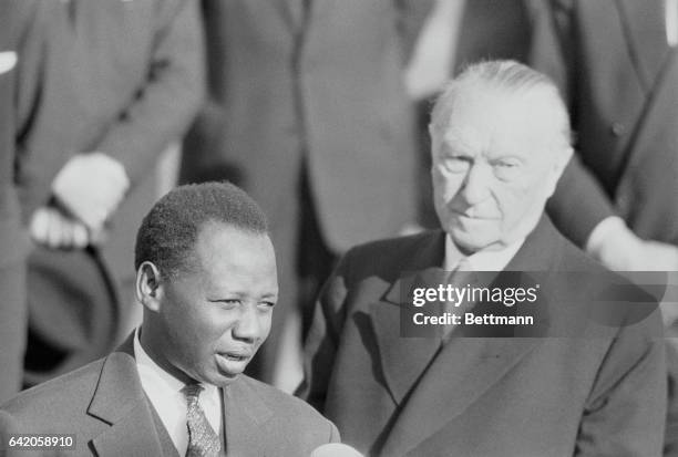 Senegalese Visitor. Bonn, West Germany: As West German chancellor Konrad Adenauer listens, Mamadou Dia , the president of the West African Republic...