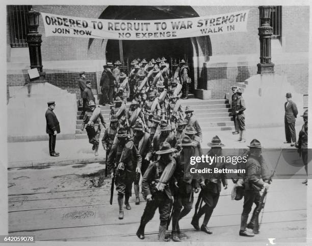 This photo shows a detachment of recruits in uniform leaving a New York Armory shortly after being enlisted.