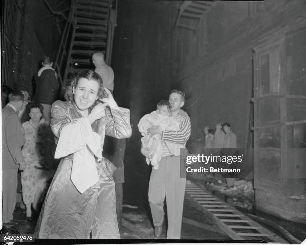 Chicago: Rush From Burning Hotel. A Major Blake carries his small son from the burning Hotel as an unidentified woman, left, also hurries to safety...