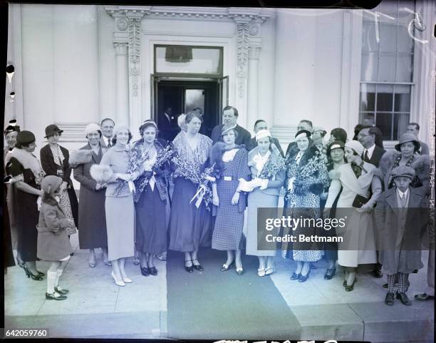 Washington, D.C.- Mrs. Franklin D. Roosevelt is tendered a basket of peach blossoms by these visitors who invited her to the annual "Blossom Time in...