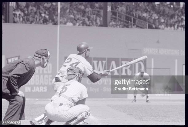 Giant slugger Willie Mays lashes a ground ball to the infield in third inning of game with Mets here. The umpire, Tony Venzon and catcher, New York's...