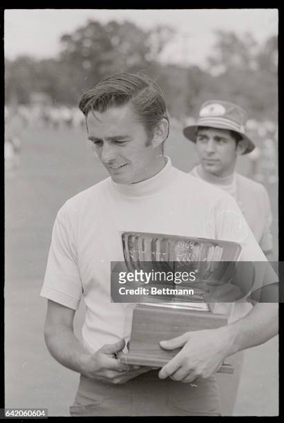 Dave Hill, of Jacksom, Michiigan, winner of the 1969 Buick Open, leaves with his trophy and a check for $25,000 after ceremonies on the 18th green...
