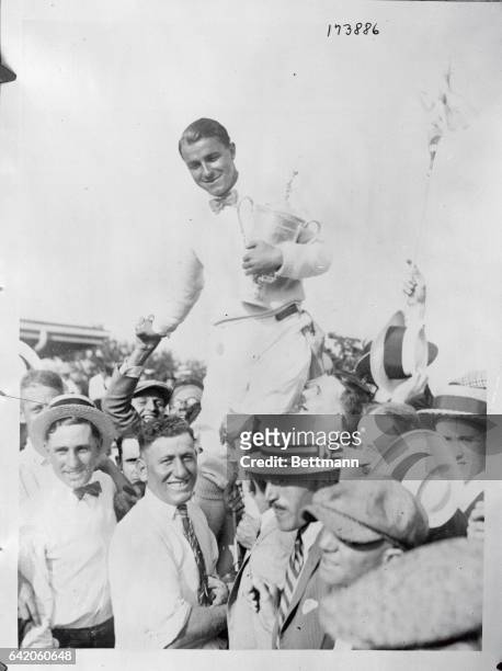 Gene Sarazen is shown following his victory in the National Open at Skokie on July 17, 1922. Held aloft by his fans, he carries his trophy.