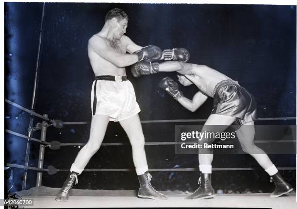 Washington, D.C.- Heavyweight Championship Joe Louis flicks out with a left against his opponent, Pat Comiskey in the third round of an exhibit bout...
