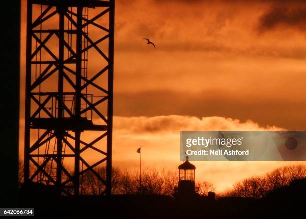 crane and lighthouse sunset - flagpole sitting stockfoto's en -beelden