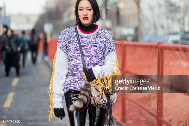 Tiffany Hsu wearing a knit, snakeskin bag, vinyl pants outside Yeezy Season 5 on February 15, 2017 in New York City.