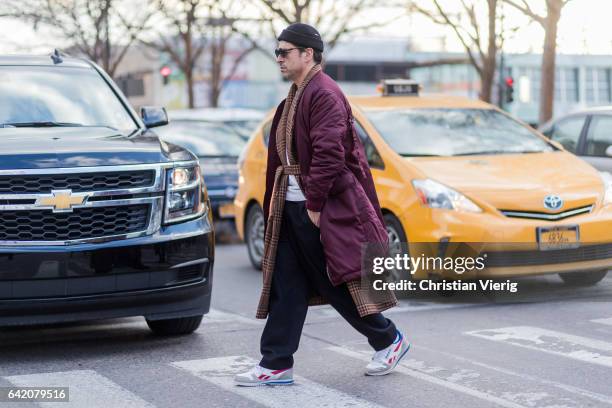 Alex Badia wearing a purple coat, beanie outside Yeezy Season 5 on February 15, 2017 in New York City.