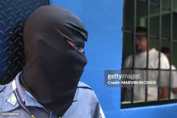 Prison guards wearing balaclavas stand guard at the entrance of the San Francisco Gotera prison, 165 km from San Salvador, on February 16, 2017. In...