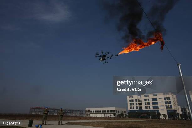 An unmanned aerial vehicle, operated by a technician, spews fire to remove a piece of plastic from the high-voltage wire on February 10, 2017 in...