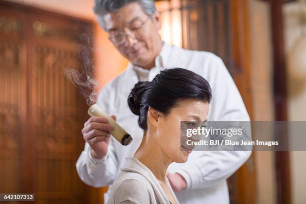 senior chinese doctor giving moxibustion - acupuncture elderly stock pictures, royalty-free photos & images