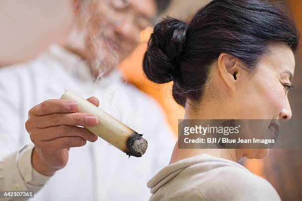 senior chinese doctor giving moxibustion - acupuncture elderly stock pictures, royalty-free photos & images