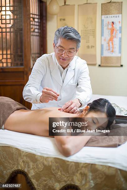 young woman receiving acupuncture - acupuncture elderly stock pictures, royalty-free photos & images