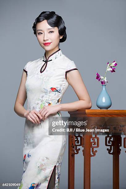 young beautiful woman in traditional cheongsam with orchid - the cheongsam stock pictures, royalty-free photos & images