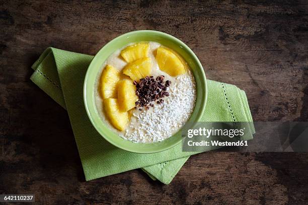 bowl of fruit smoothie garnished with pineapple slices, coconut flakes and chocolate shaving - chocolate chunks top view stock pictures, royalty-free photos & images