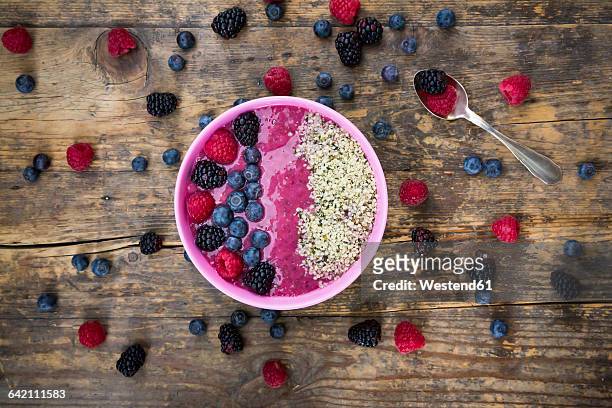 bowl with fruit smoothie garnished with berries and hemp seeds - chia seed stock-fotos und bilder