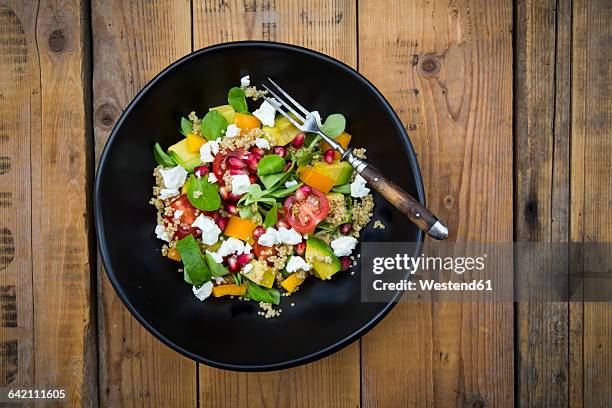 salad bowl with lamb's lettuce, quinoa, yellow bell pepper, cocktail tomato, avocado, feta and pomegranate seeds - feldsalat stock-fotos und bilder