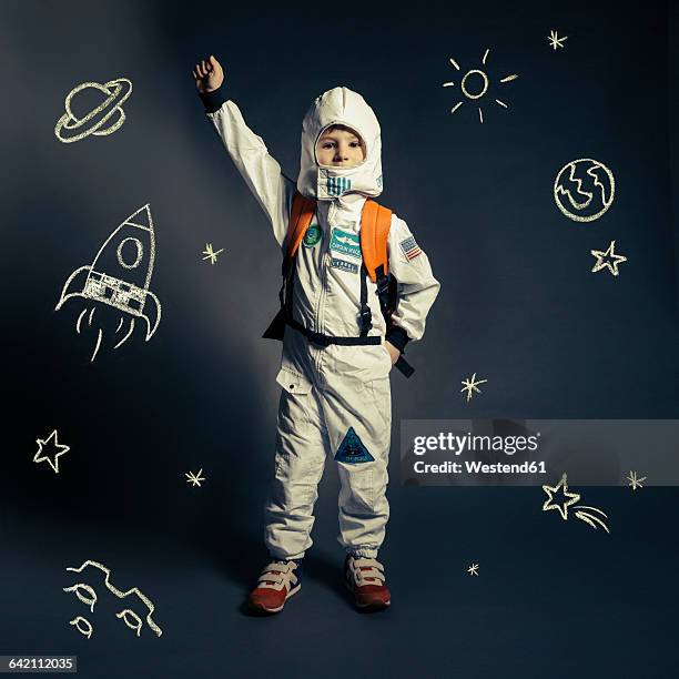 child with spacesuit orbited by celestial bodies and luminaries - astronaut kid stock pictures, royalty-free photos & images