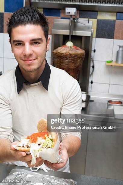 young chef holding a dner kebab - dner stockfoto's en -beelden