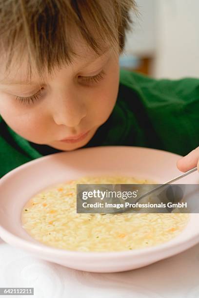 small boy eating noodle soup - pâtes alphabet photos et images de collection