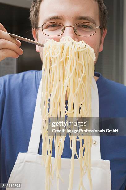 chef holding up cooked spaghetti on spaghetti server - spaghetti hair stock pictures, royalty-free photos & images