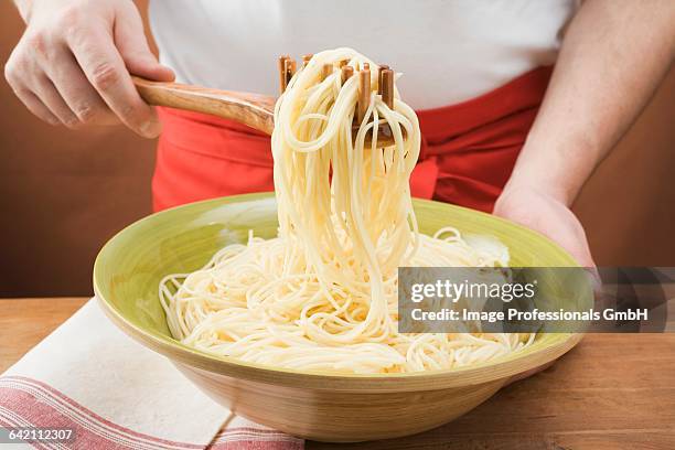 picking up cooked spaghetti with spaghetti server - spaghetti spoon stock pictures, royalty-free photos & images