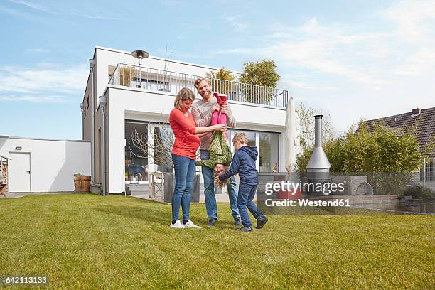 portrait of happy family with pregnant mother in garden - stéréotype de la classe moyenne photos et images de collection
