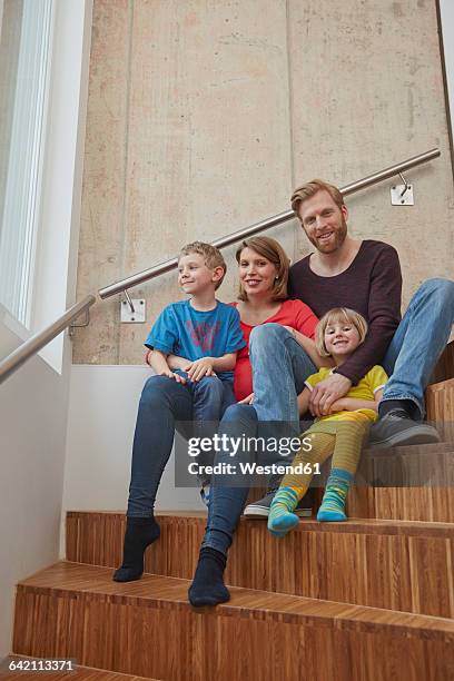 portrait of smiling family sitting on stairs - family tree stockfoto's en -beelden