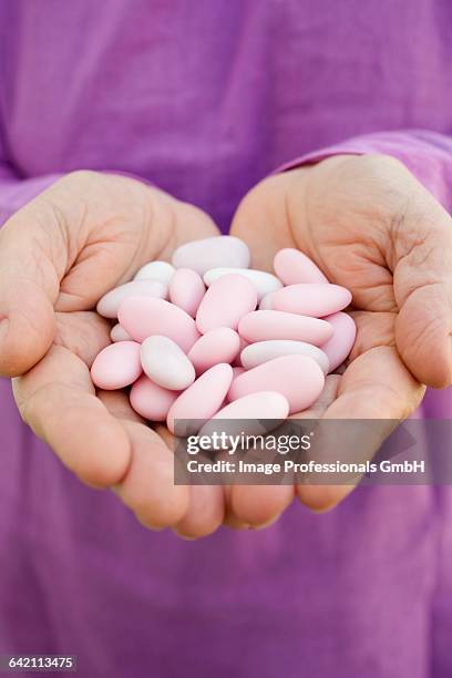 hands holding sugared almonds - sugared almond stock pictures, royalty-free photos & images