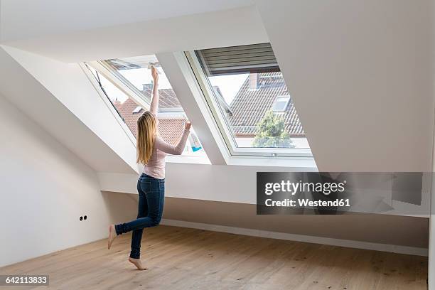 woman cleaning window in her new penthouse - women of penthouse stock pictures, royalty-free photos & images