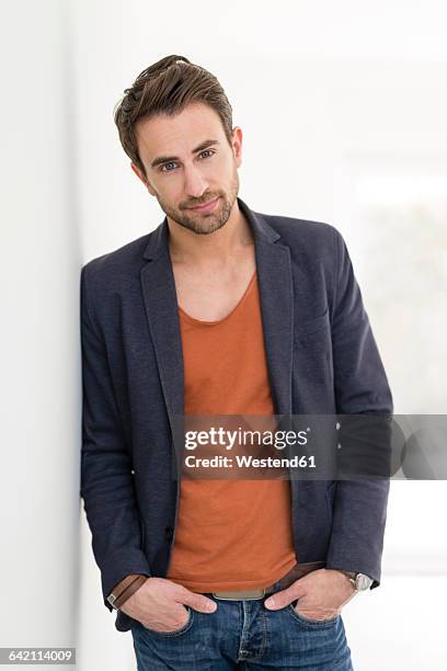 portrait of man leaning against wall - stubble imagens e fotografias de stock