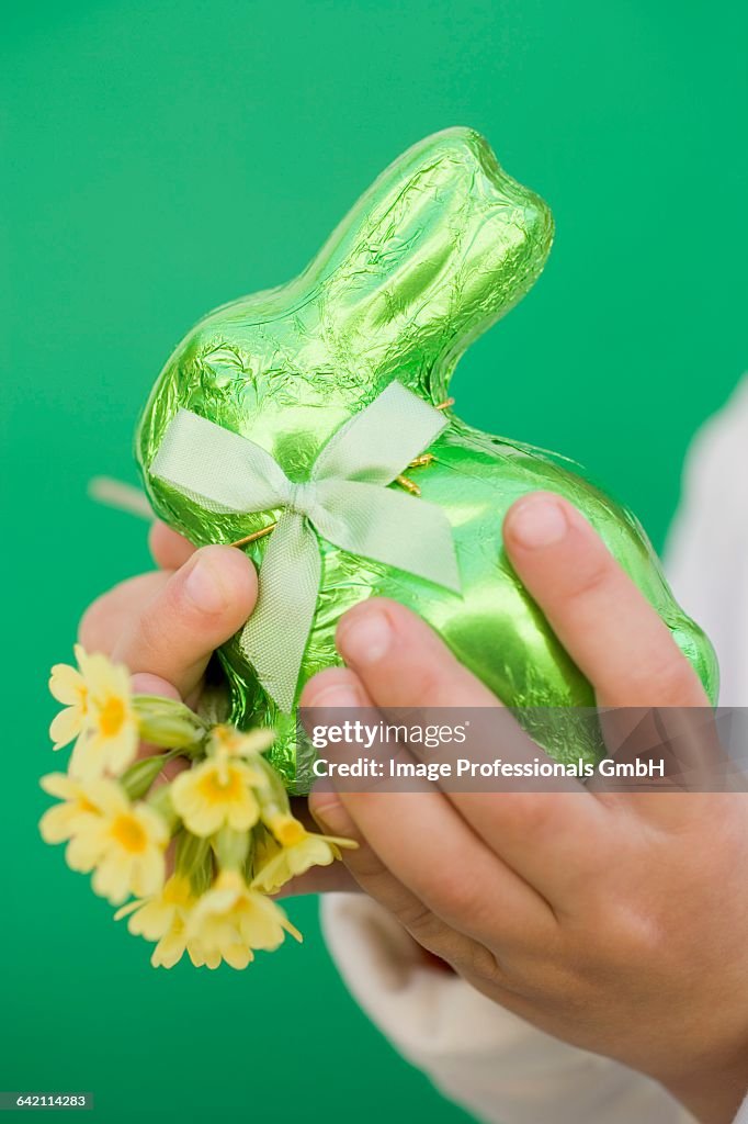 Childs hands holding green Easter Bunny