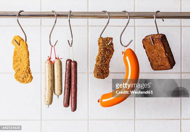 vegan and vegetarian sausages and steaks hanging on hooks - vegetarian food stock pictures, royalty-free photos & images