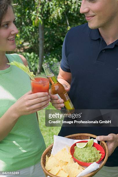 young couple with guacamole, chips and drinks - americana aloe stock pictures, royalty-free photos & images