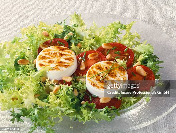 hot goats cheese salad on sliced tomatoes - curly endive stock pictures, royalty-free photos & images