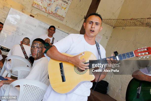 Member of the "Barrio 18 Revolucionarios" gang plays the guitar and sing at the San Francisco Gotera Prison on February 16, 2017 in Morazan, El...