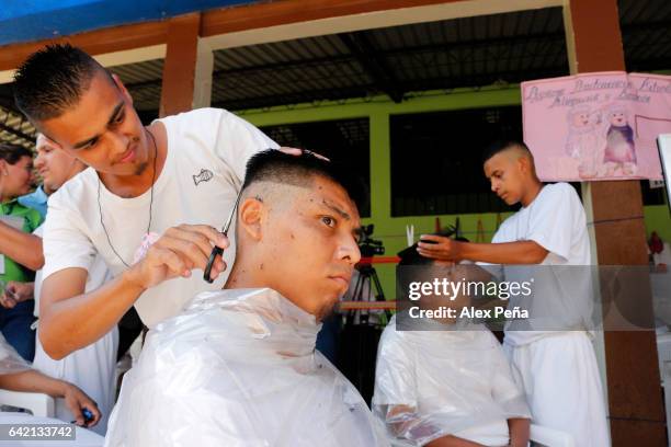 Member of the "Barrio 18 Revolucionarios" cuts hair to another one at the San Francisco Gotera Prison on February 16, 2017 in Morazan, El Salvador....